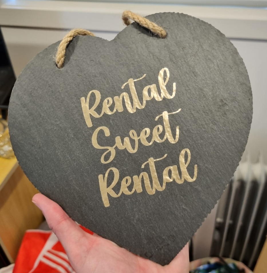 Heart-shaped plaque with ‘Rental Sweet Rental’ text applied using vinyl, ideal for home décor and side hustle projects.