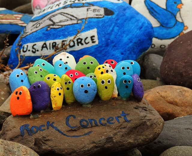 A group of smooth pet rocks painted with colorful, expressive faces/